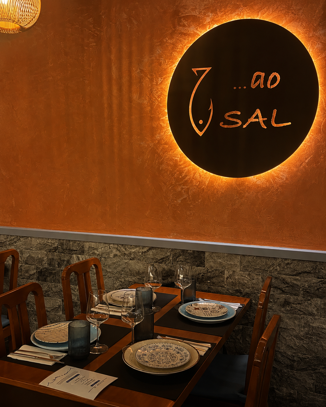 Parede com logotipo dourado do Ao Sal na sala principal